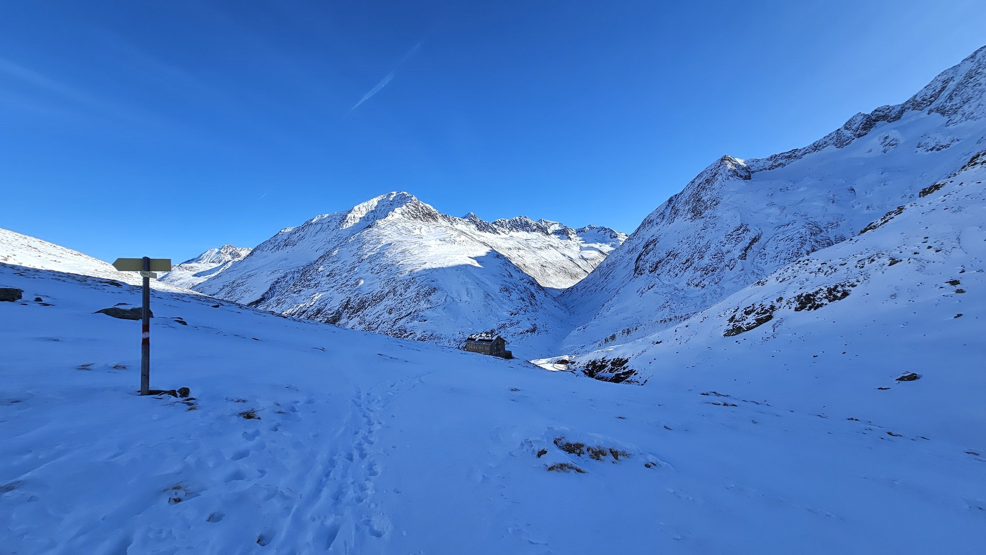Zasypany śniegiem szlak i drogowskaz w Alpach Ötztalskich